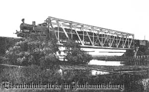 Pociąg przejeżdża przez most kolejowy w Piszu. Pocztówka sprzed I wojny światowej z archiwum Bogdana Chojniaka.