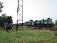 30.07.2010, Stare Juchy, 19:25. Spotkanie trzech rodzajów trakcji: TEM2-098 i 182 118-0 jako pociąg ZXS 556558 relacji Olsztyn - Ełk, a po lewej parowóz pomnik Ol49-29. Transport tłucznia do remontu odcinka linii kolejowej Ełk - Orzysz.